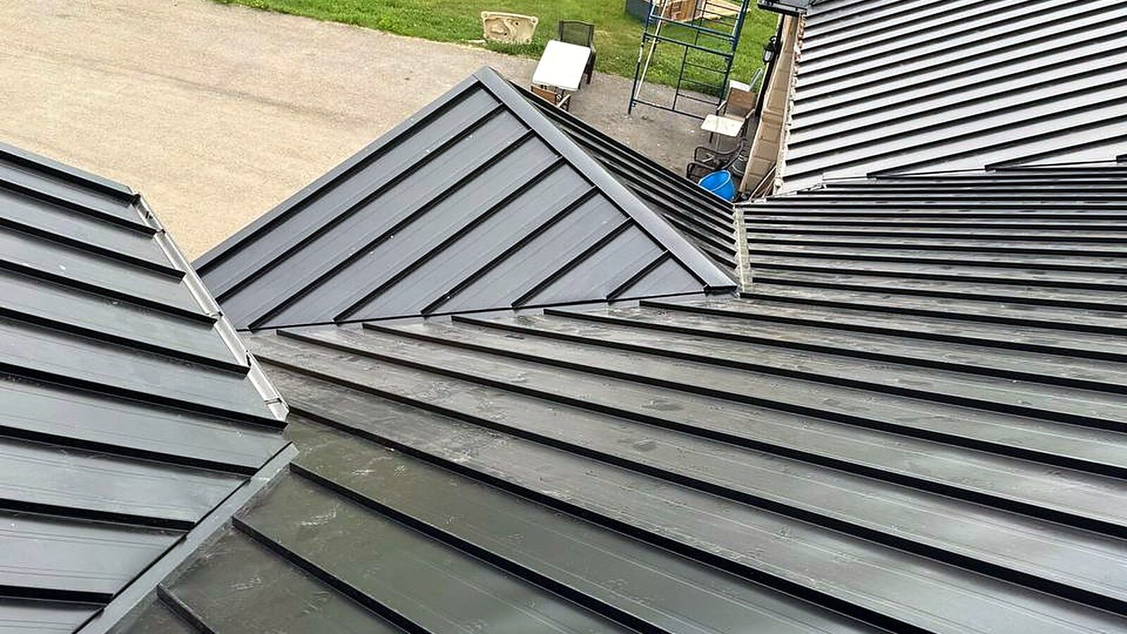 Black standing seam metal roof running from the ridge down to the eave on an acreage home