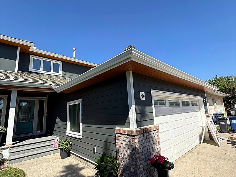 Blue-grey lap siding with cedar-tone soffit on a two-storey home