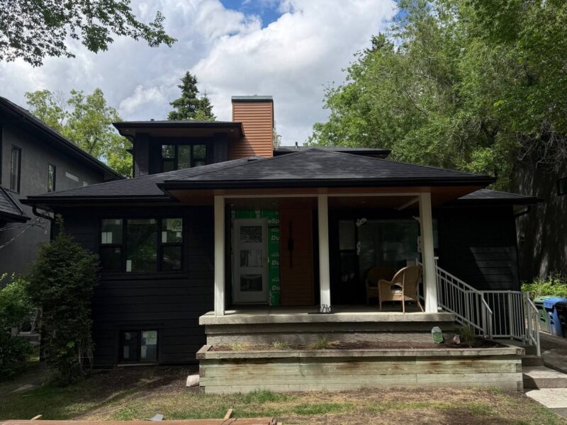 Front elevation of a dark siding home with a covered porch