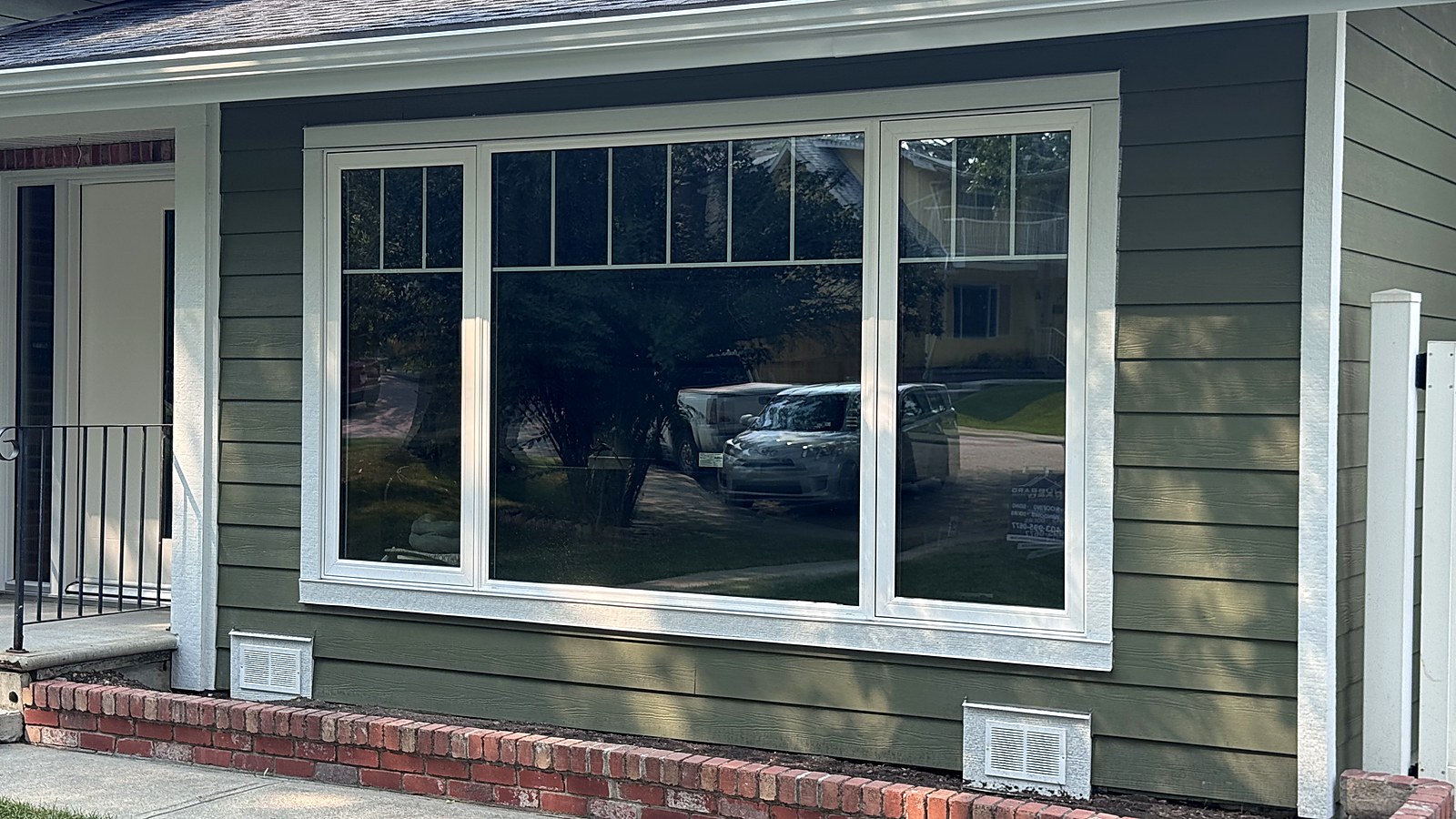 Finished lap siding and wide white window trim on a Calgary bungalow front