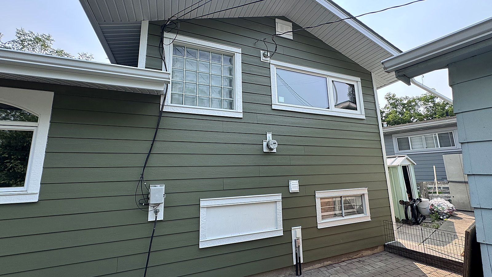 Green lap siding across a full side elevation with white window trim
