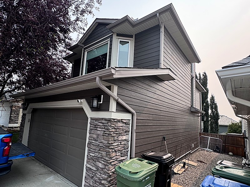 Grey lap siding with a stone skirt on a two-storey Calgary home