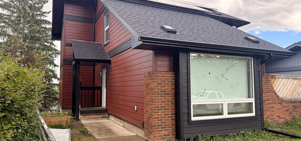 Dark red and charcoal lap siding on a two-storey Calgary home after a full re-side