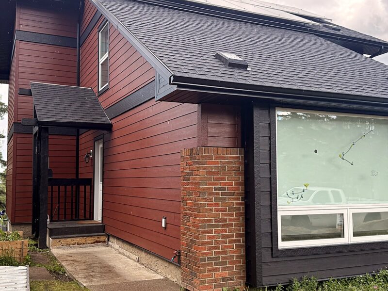 Dark red and charcoal lap siding on a two-storey Calgary home after a full re-side