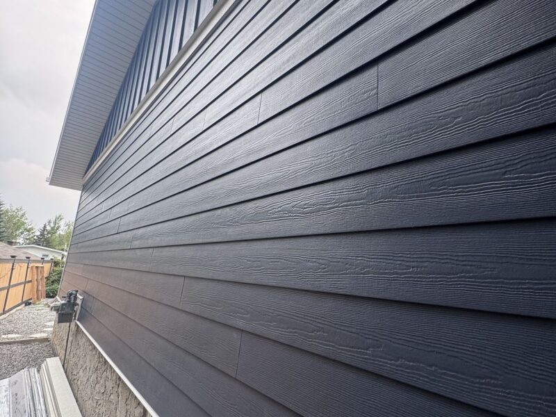 Close-up of navy fibre cement lap siding on a house wall