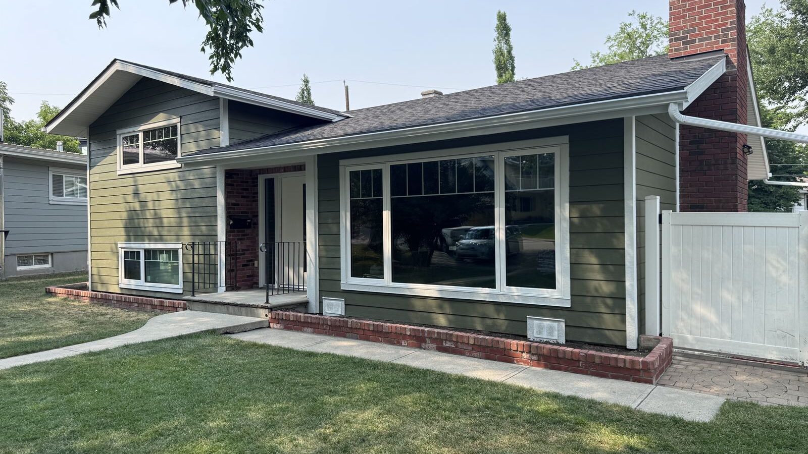 Finished sage siding bungalow with white trim