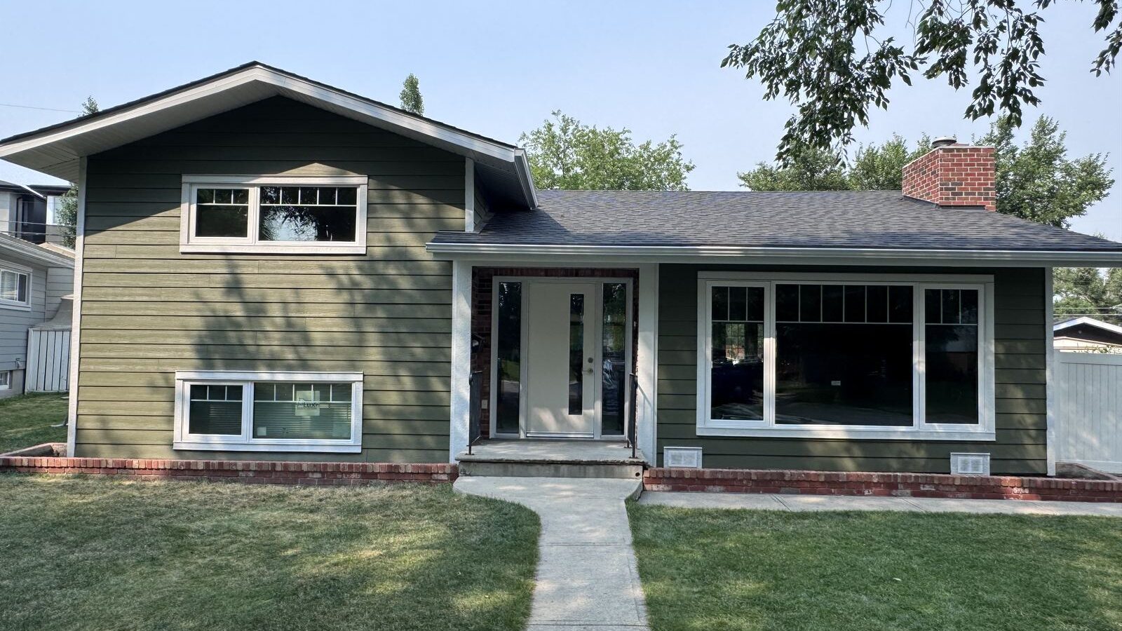 Sage green lap siding and new windows on a finished bungalow front elevation