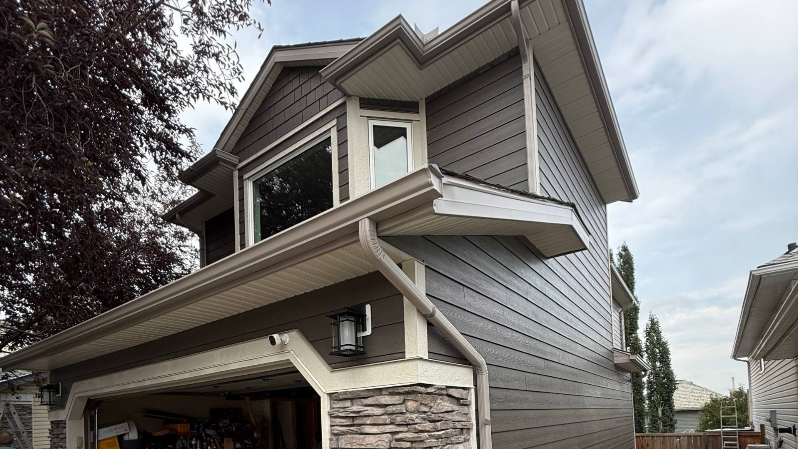 Soffit and fascia along the eaves, bay overhang and porch gable of a grey home