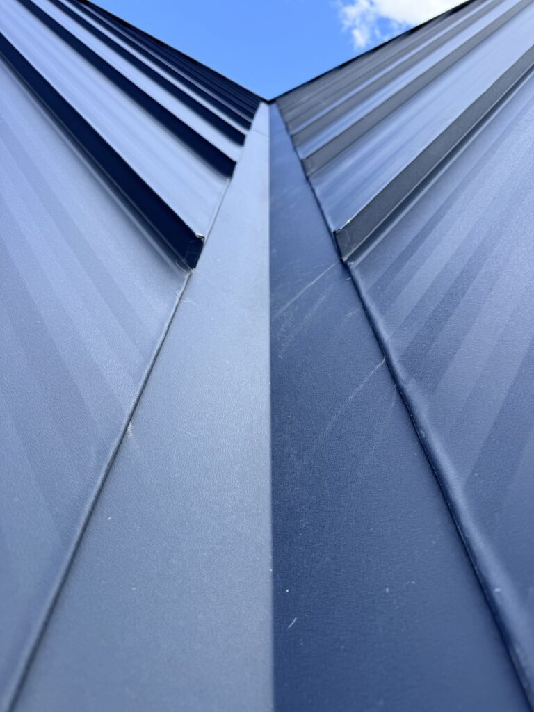 Two standing seam roof planes meeting at the ridge, close view